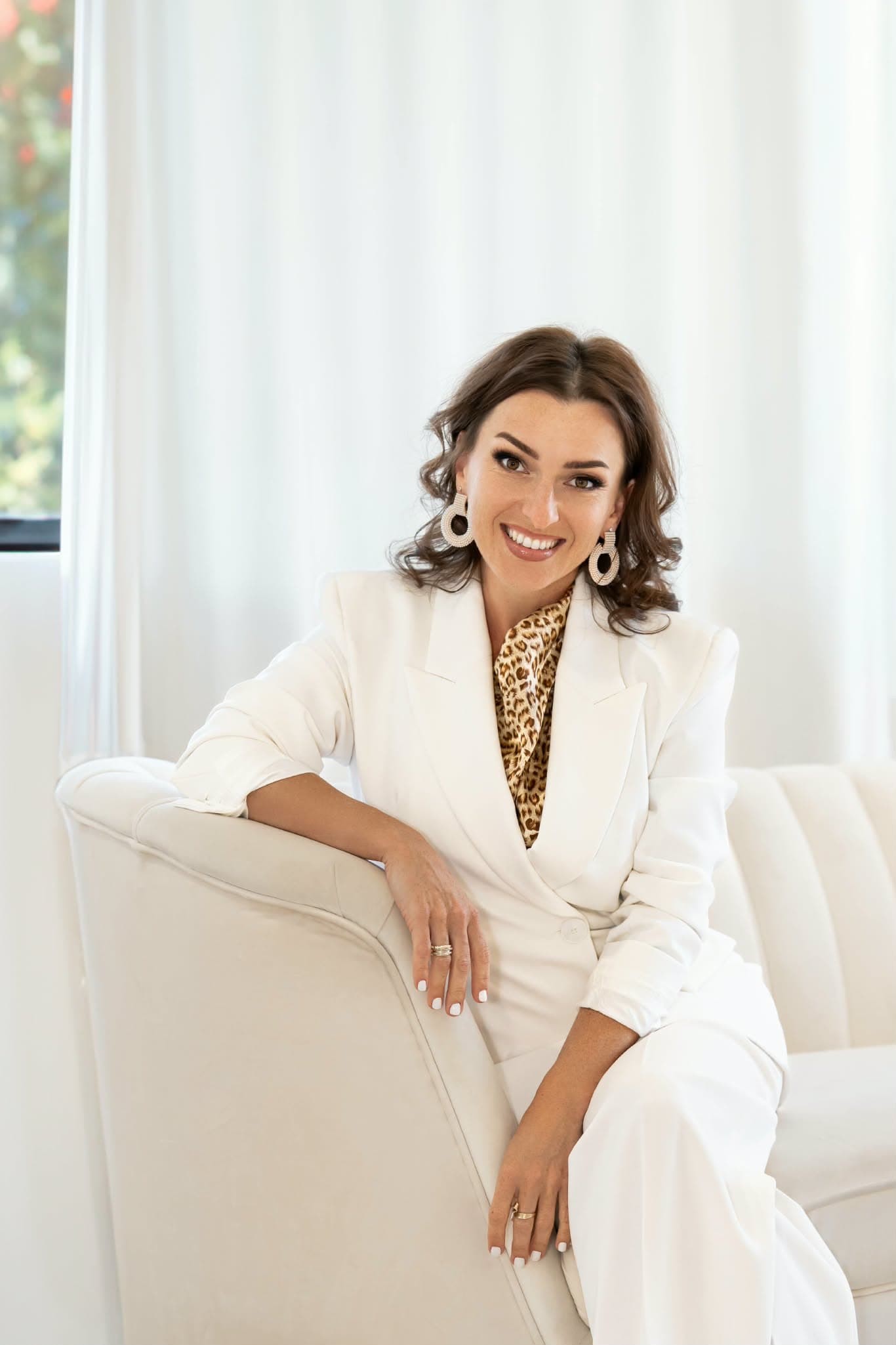 Julia Zoger seated in a white suit
